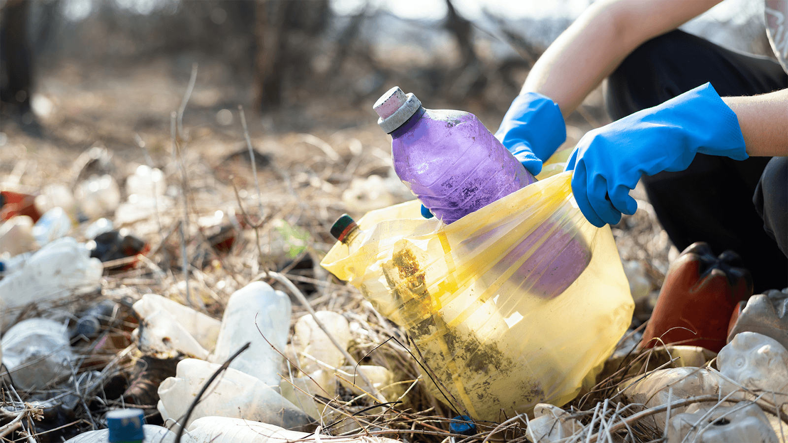 Man picking up plastic trash from a landfill